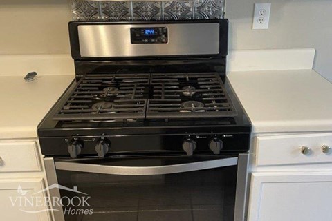 a black stove top oven in a white kitchen