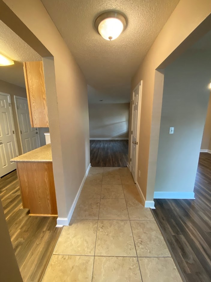 a view of a hallway from a home with wood floors and blue walls