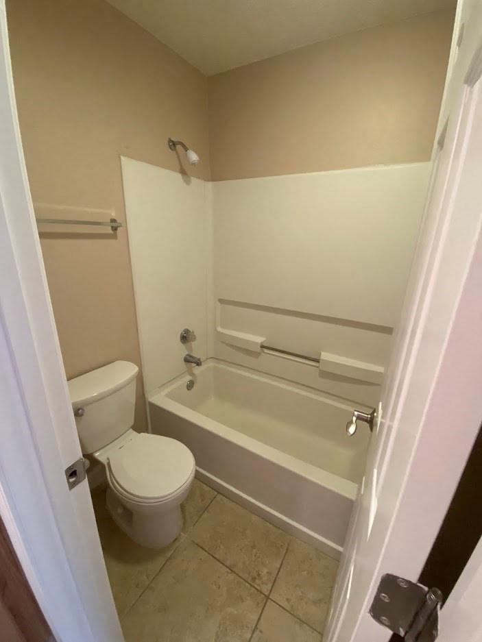 a bathroom with a toilet and a bath tub