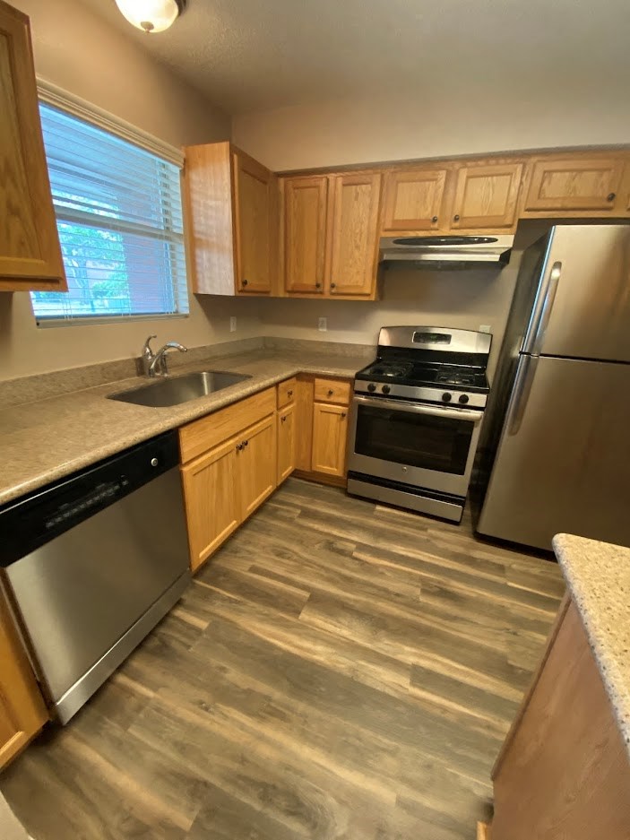 a kitchen with wooden cabinets and stainless steel appliances