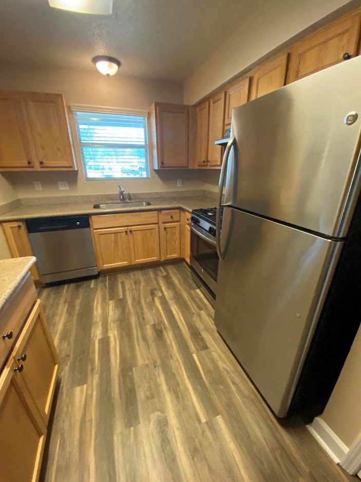 a kitchen with a stainless steel refrigerator and wooden cabinets