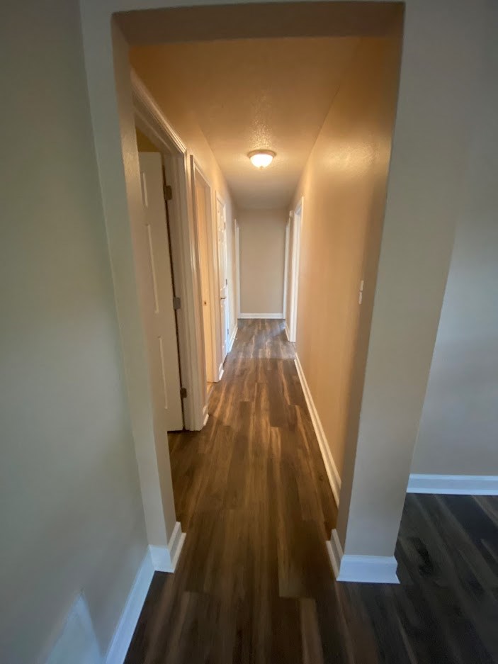 a hallway with wooden floors and white walls