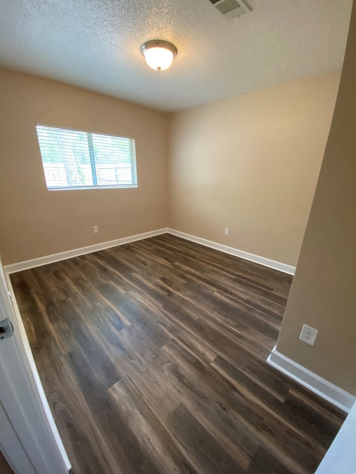 a empty room with wooden floors and a window