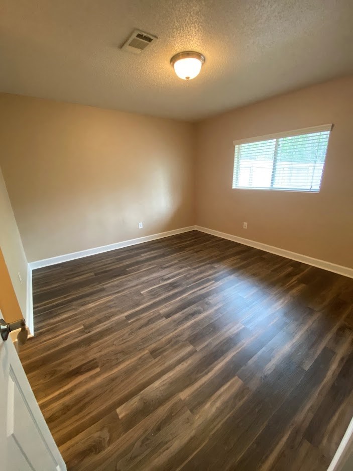 a empty room with wooden floors and a window