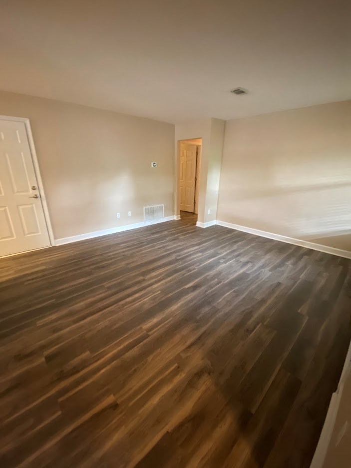 an empty living room with a wooden floor