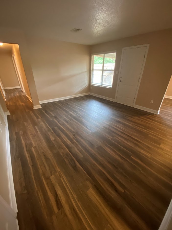 a empty living room with a hard wood floor
