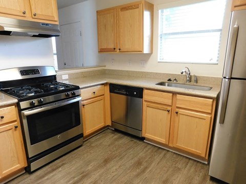 A kitchen with wooden cabinets and stainless steel appliances.