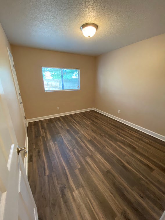 an empty room with wooden floors and a window