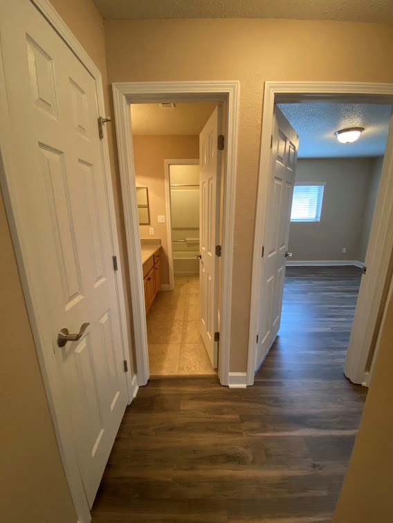 a hallway with a door open to a bedroom and a bathroom