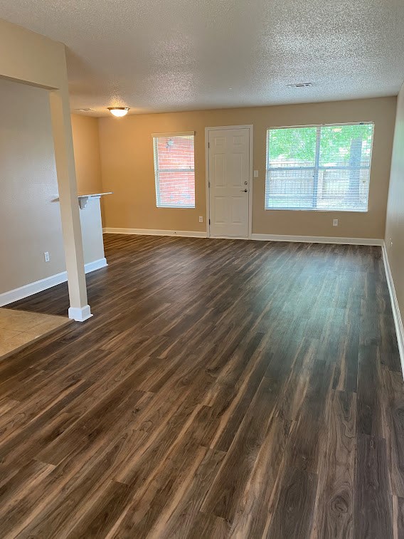 an empty living room with a hard wood floor