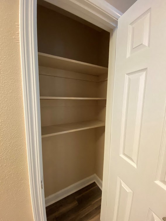an empty closet with shelves and a white door