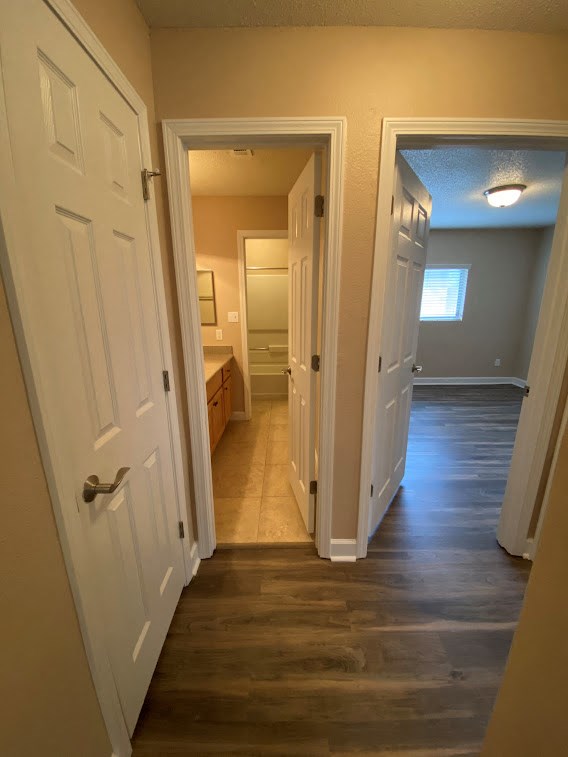 a hallway with a door open to a bedroom and a bathroom