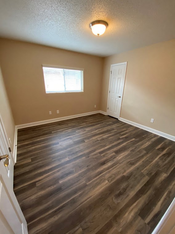 a empty room with wooden floors and a white door