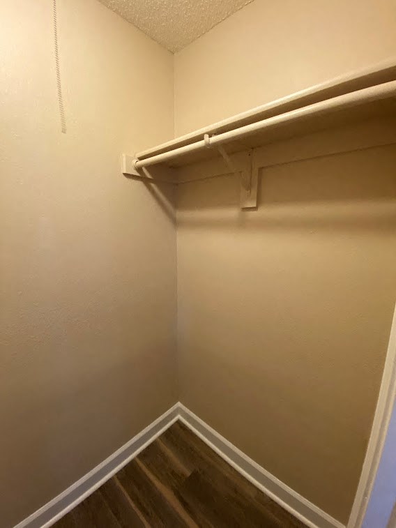 a empty closet with a white wall and a long white shelf