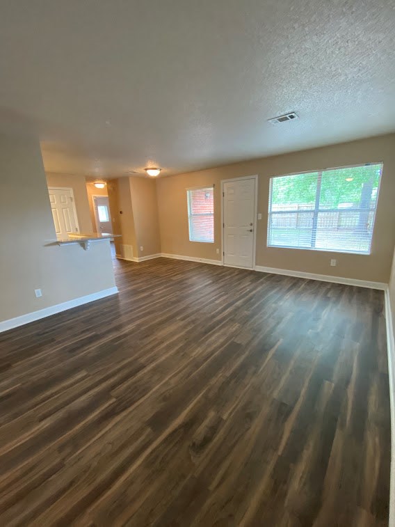an empty living room with a hard wood floor