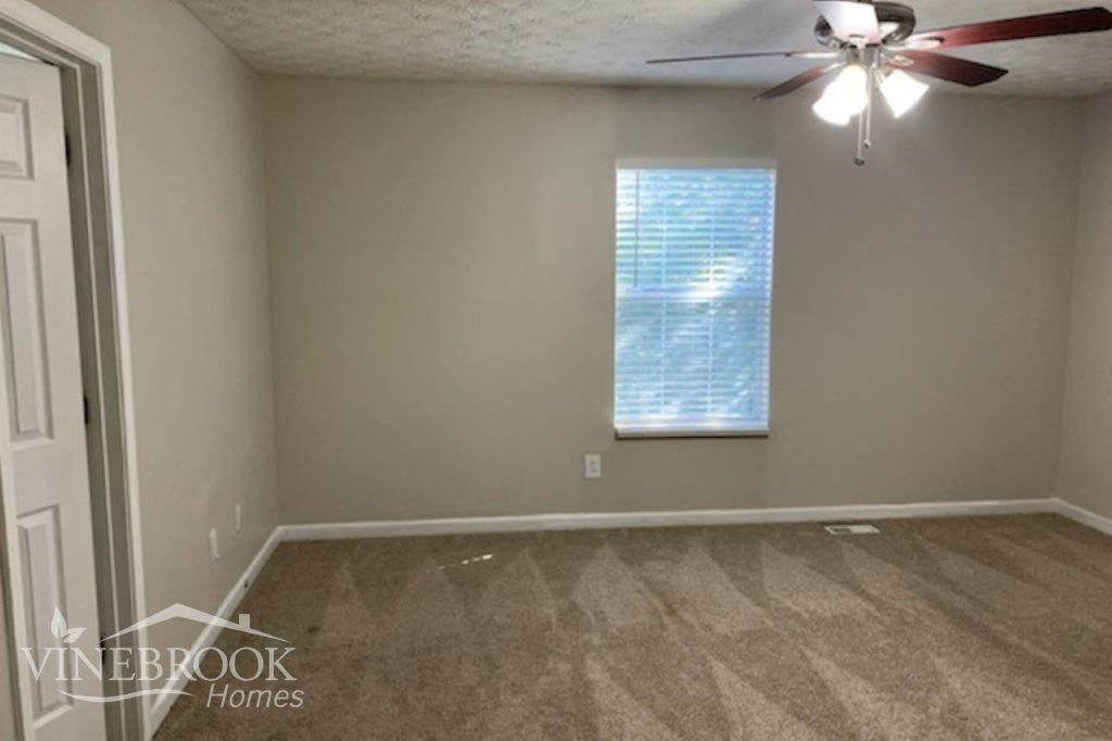 a empty room with a ceiling fan and a window
