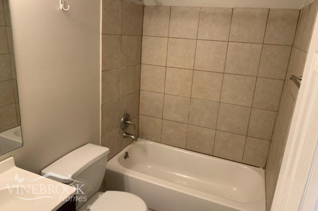 a bathroom with a toilet and a bath tub