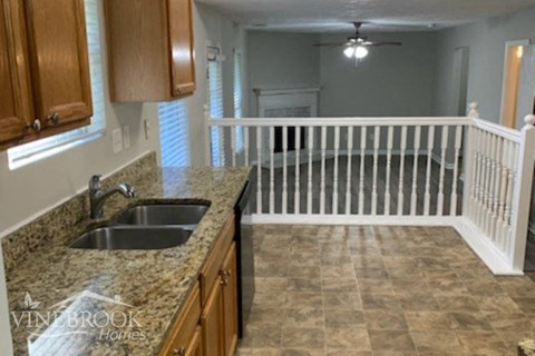 a kitchen with a sink and a white railing