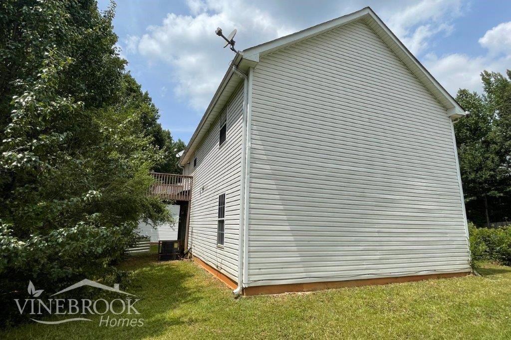 a small white barn with a cross on top of it