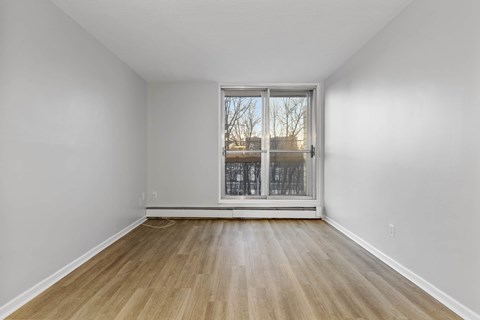 A room with a wooden floor and a sliding glass door.