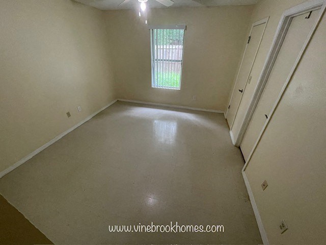 A room with a window and a door is empty and waiting to be furnished.