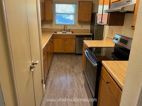 A kitchen with wooden cabinets and a black oven.