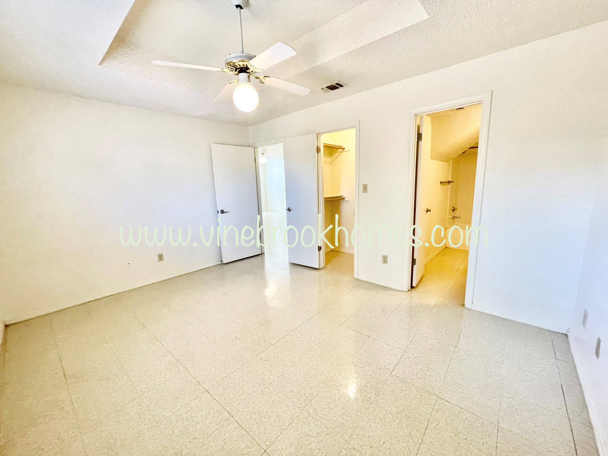 two closets in the living room with a ceiling fan