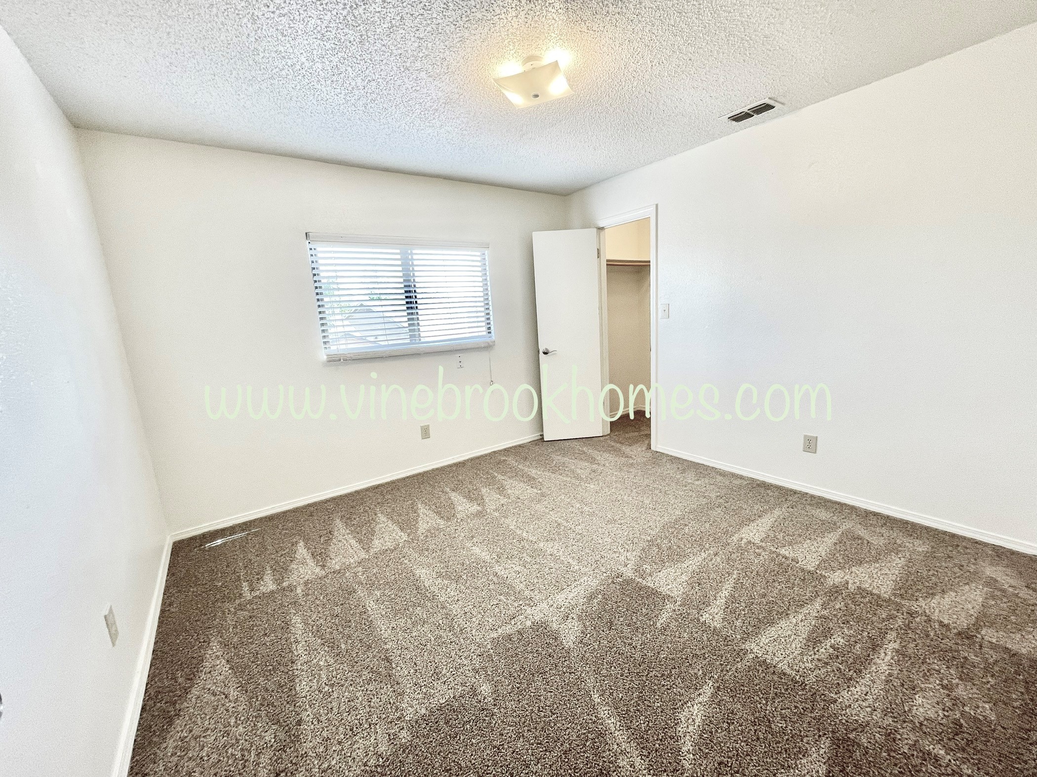 a bedroom with a closet and a carpeted floor