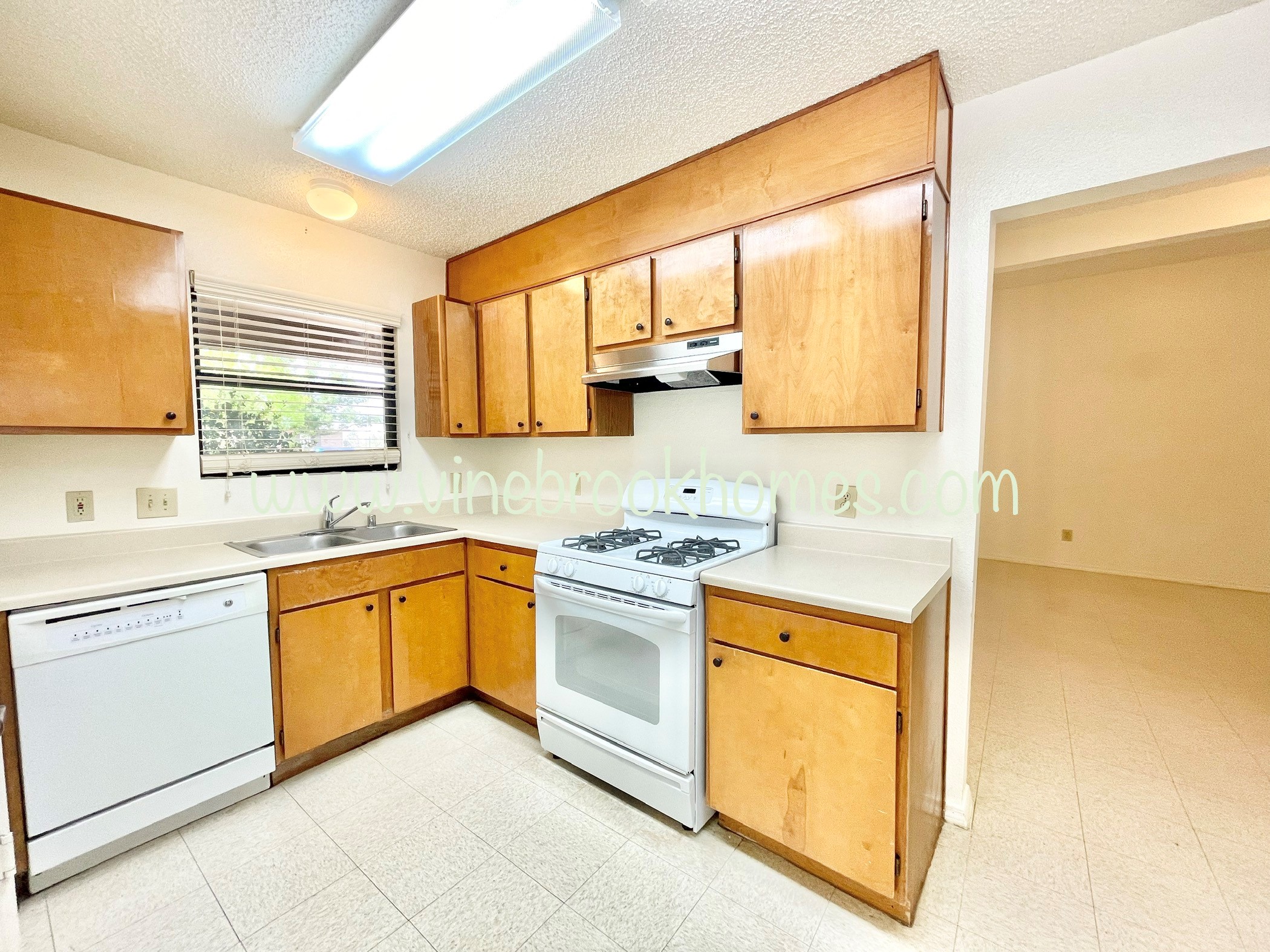 a kitchen with white appliances and wooden cabinets