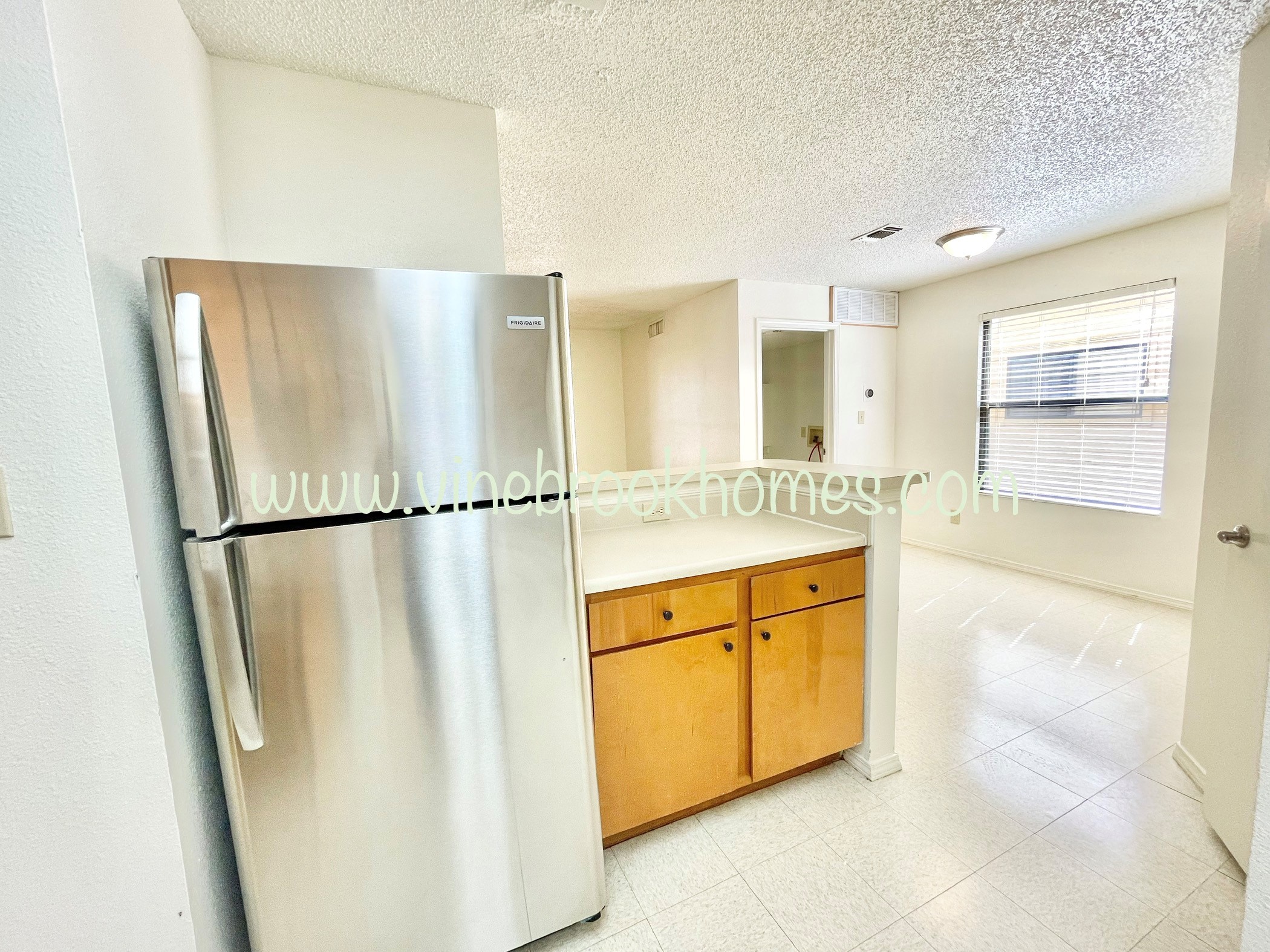 a kitchen with a stainless steel refrigerator and a counter top