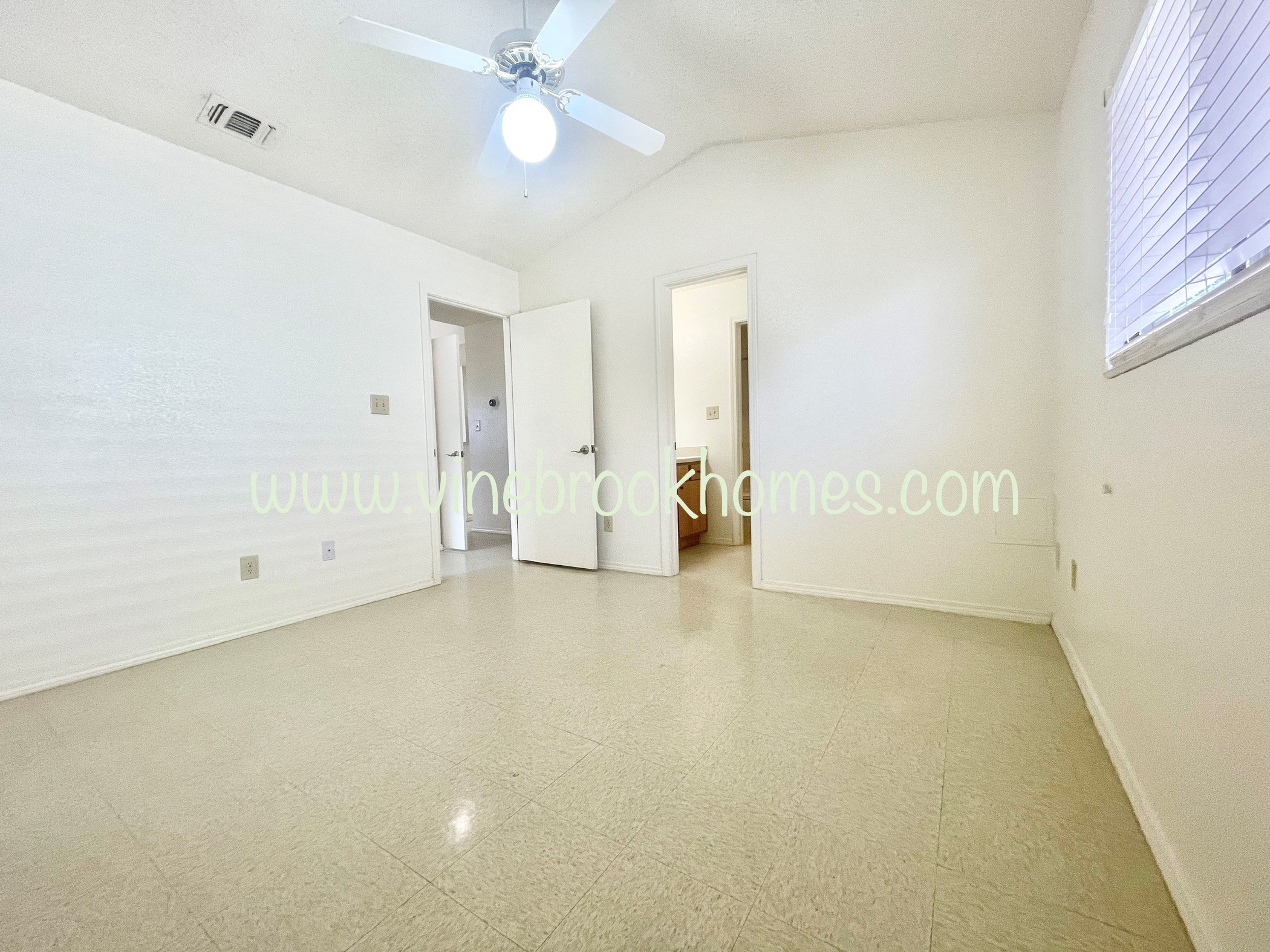 a large living room with a ceiling fan and a closet