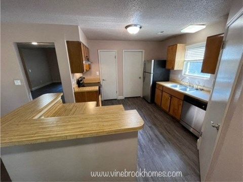 a kitchen with a counter and a sink and a refrigerator