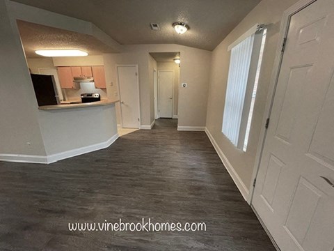 a hallway with a kitchen and a living room