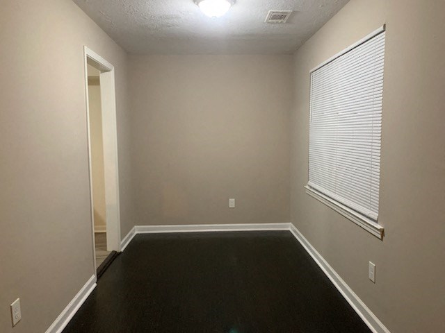 a empty room with a large window and black carpet