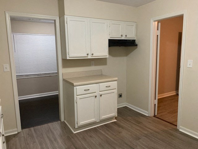 an empty kitchen with white cabinets and a sink