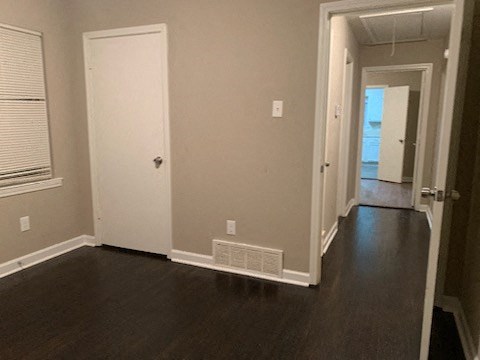 an empty room with a hallway and a door