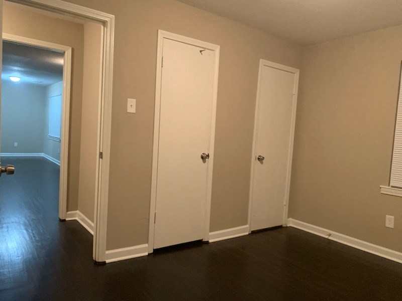 an empty room with two doors and a dark floor