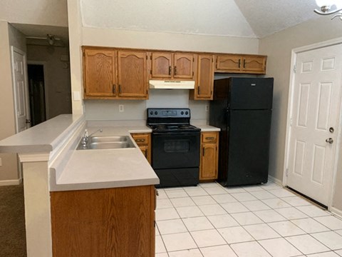 a kitchen with a stove refrigerator and a sink