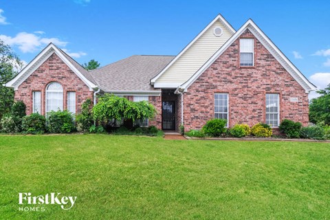a brick house with a lawn in front of it