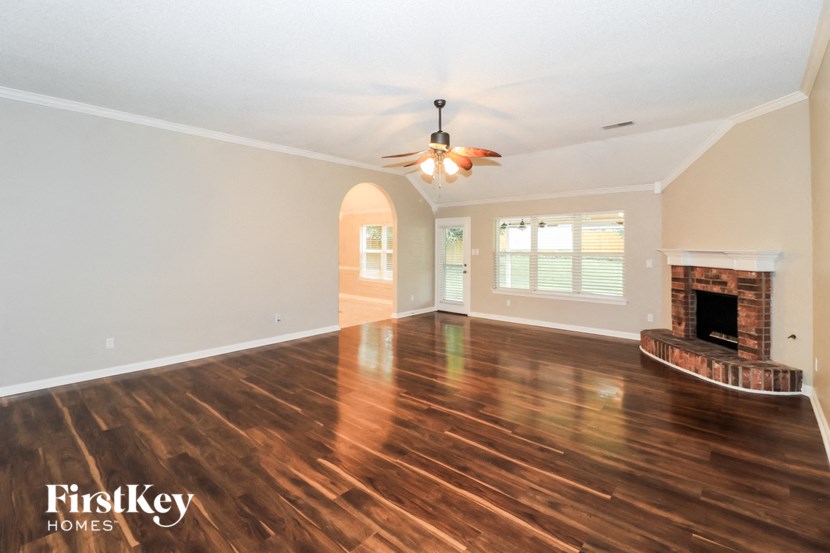 a living room with a fireplace and a ceiling fan