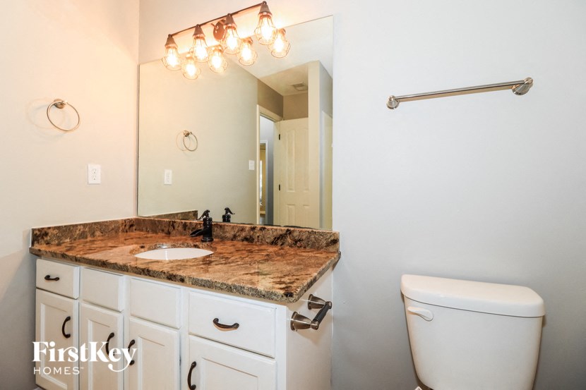 a bathroom with a toilet and a sink and a mirror