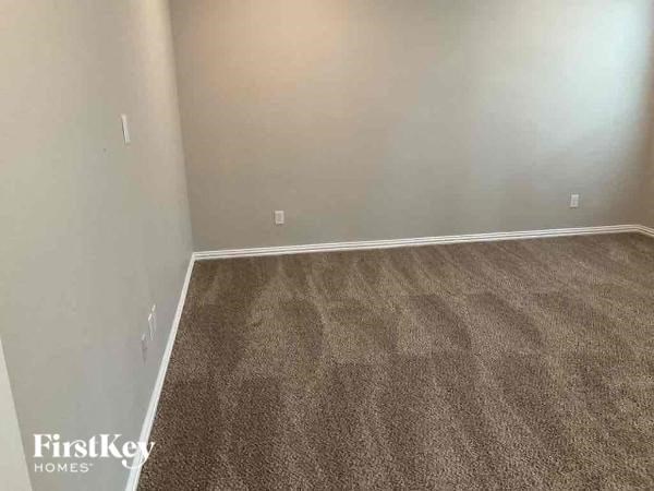a empty room with brown carpet and white walls