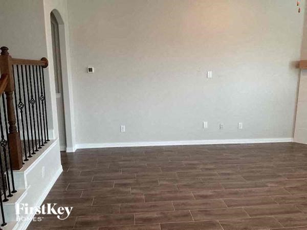 a empty living room with white walls and a wooden floor