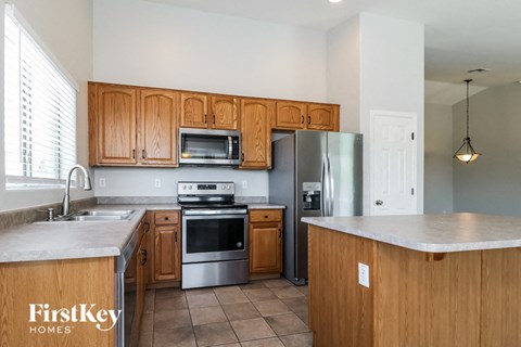 A kitchen with wooden cabinets and a stainless steel refrigerator.