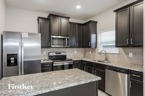 A kitchen with granite countertops and stainless steel appliances.