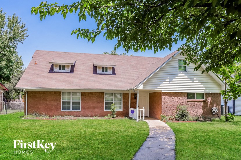 a brick house with a sidewalk in front of it