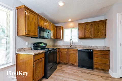 a kitchen with wooden cabinets and black appliances