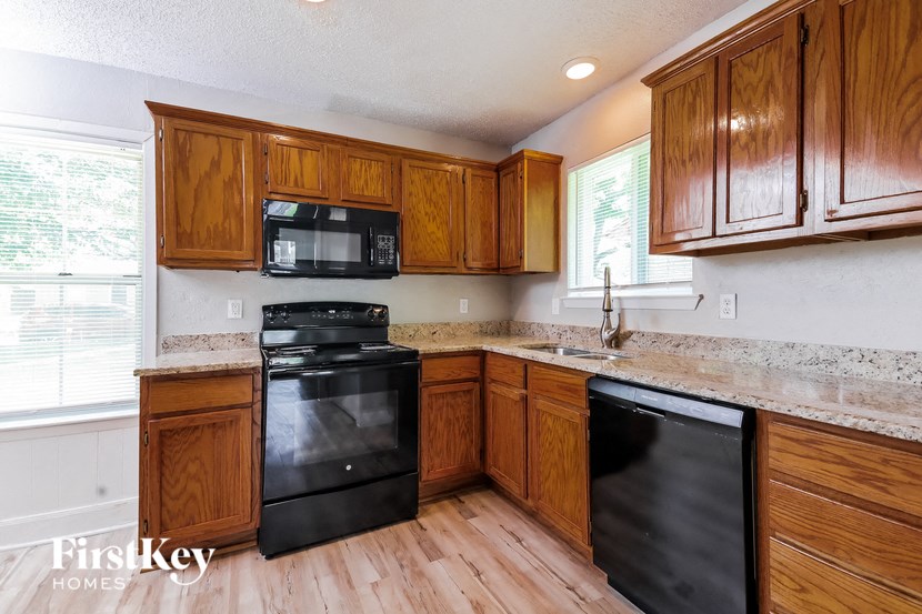 a kitchen with wooden cabinets and black appliances
