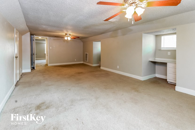 an empty living room and kitchen with a ceiling fan