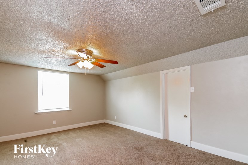 a living room with a ceiling fan and a door